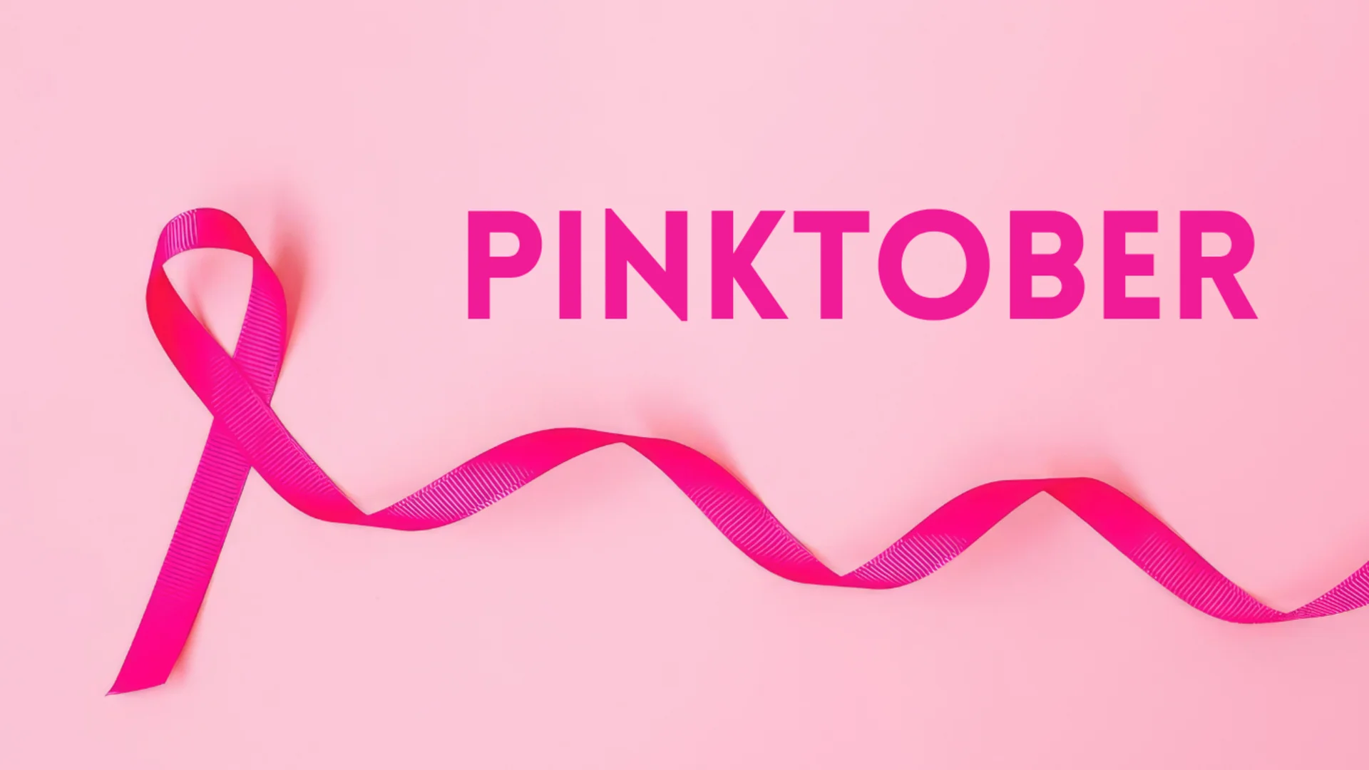 Eine pinke Schleife liegt auf einem pinken Hintergrund. Darüber steht in großen, auffälligen Buchstaben das Wort "PINKTOBER".