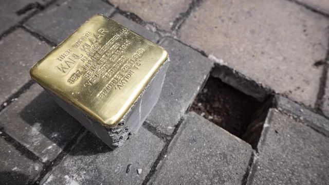 Ein Stolperstein aus Bronze mit der Inschrift zu Ehren von Karl W. Heimer. Er gehört zu einer Gedenkaktion für Opfer des Nationalsozialismus. Der Stein liegt auf dem Gehweg, umgeben von Pflastersteinen und einem leeren Platz, wo ein weiterer Stein platziert werden könnte.
