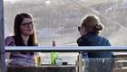 Zwei Frauen sitzen am Tisch und unterhalten sich