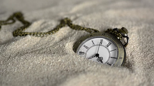 Eine Taschenuhr im Sand