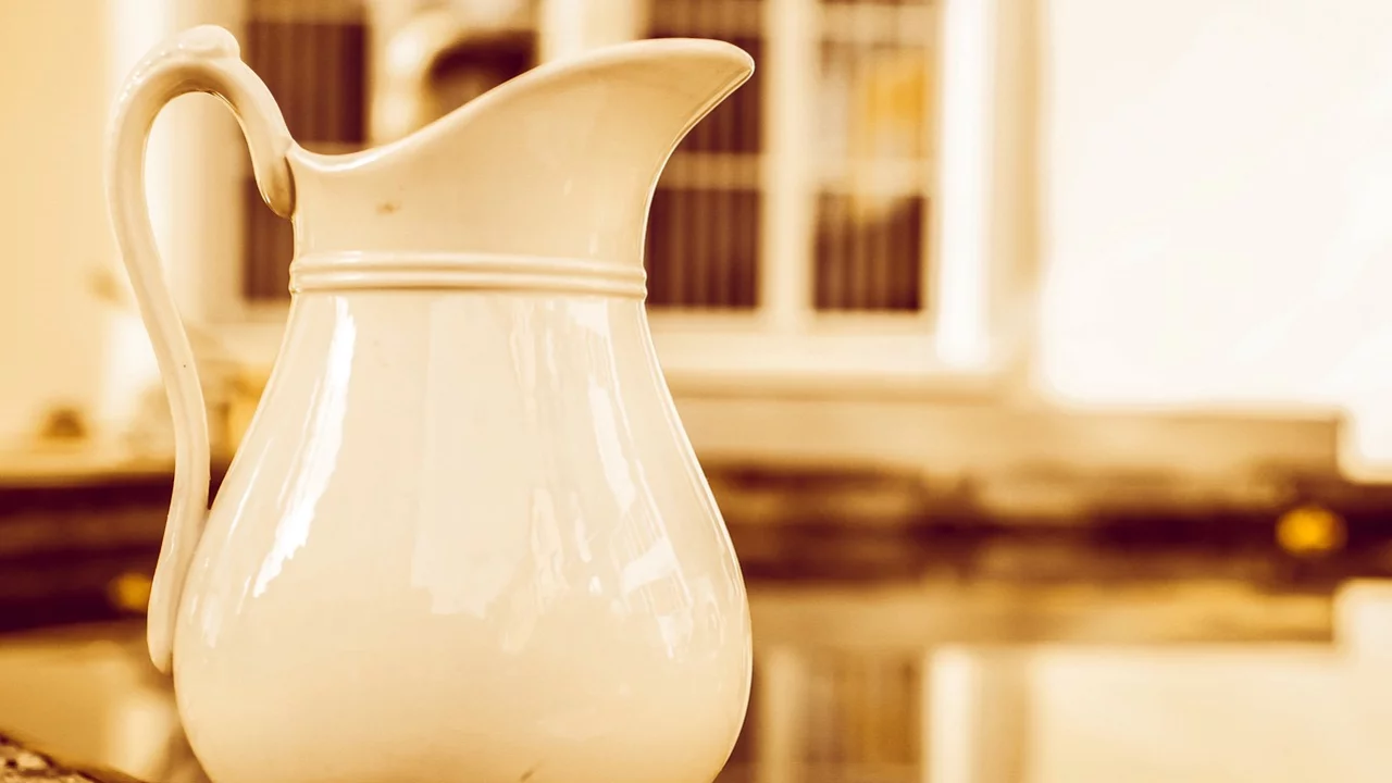 Ein Krug steht auf einer Brunnenmauer. 