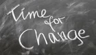 Auf einer Tafel steht in kreidiger Schrift der Satz: "Time for Change". Der Text vermittelt die Botschaft, dass es Zeit für Veränderungen ist.