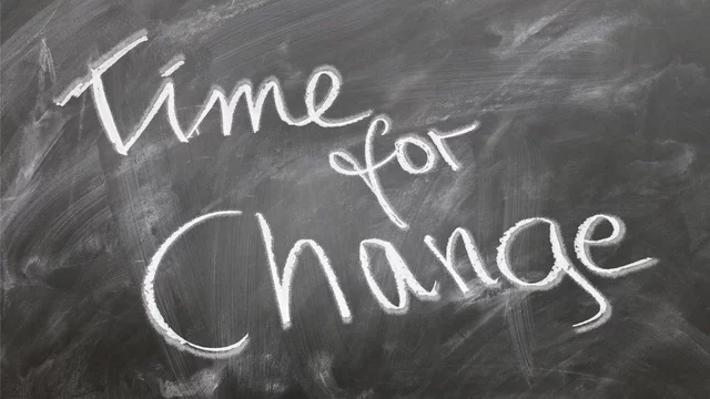 Auf einer Tafel steht in kreidiger Schrift der Satz: "Time for Change". Der Text vermittelt die Botschaft, dass es Zeit für Veränderungen ist.
