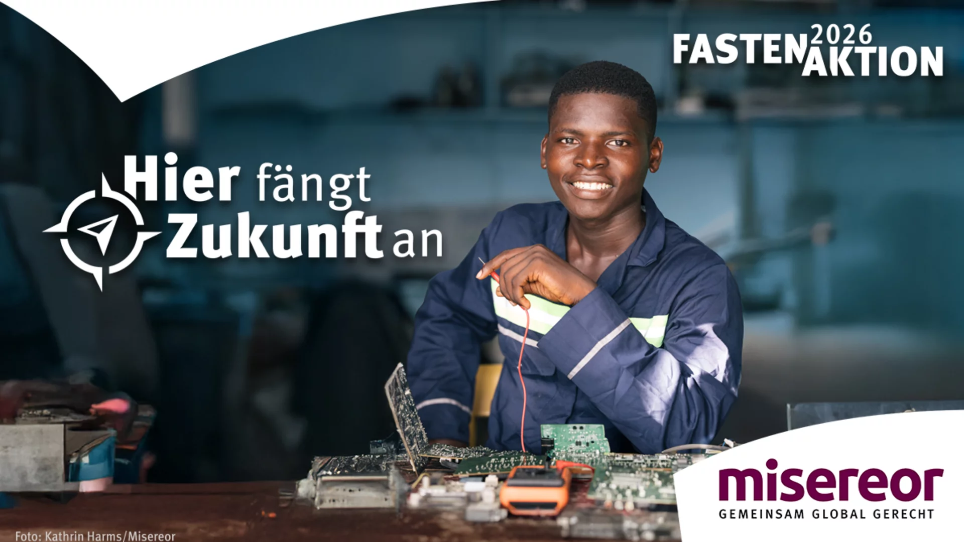 Ein junger Mann lächelt und arbeitet an einer elektronischen Platine. Neben ihm steht der Slogan „Hier fängt Zukunft an“. Das Bild vermittelt ein Gefühl von Hoffnung und der Möglichkeit, durch Bildung und Arbeit eine bessere Zukunft zu gestalten. Im Hintergrund sind Materialien und Werkzeuge sichtbar.