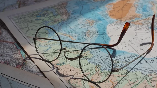 Eine Brille liegt auf einer Weltkarte. 