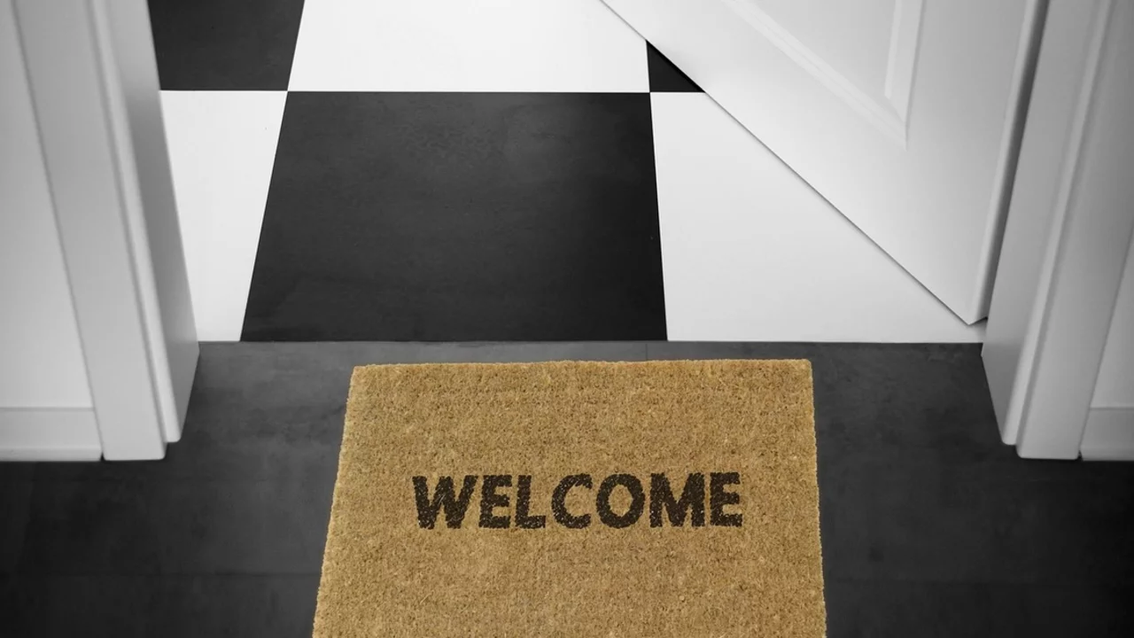 Geöffnete Tür mit Fußmatte davor. 