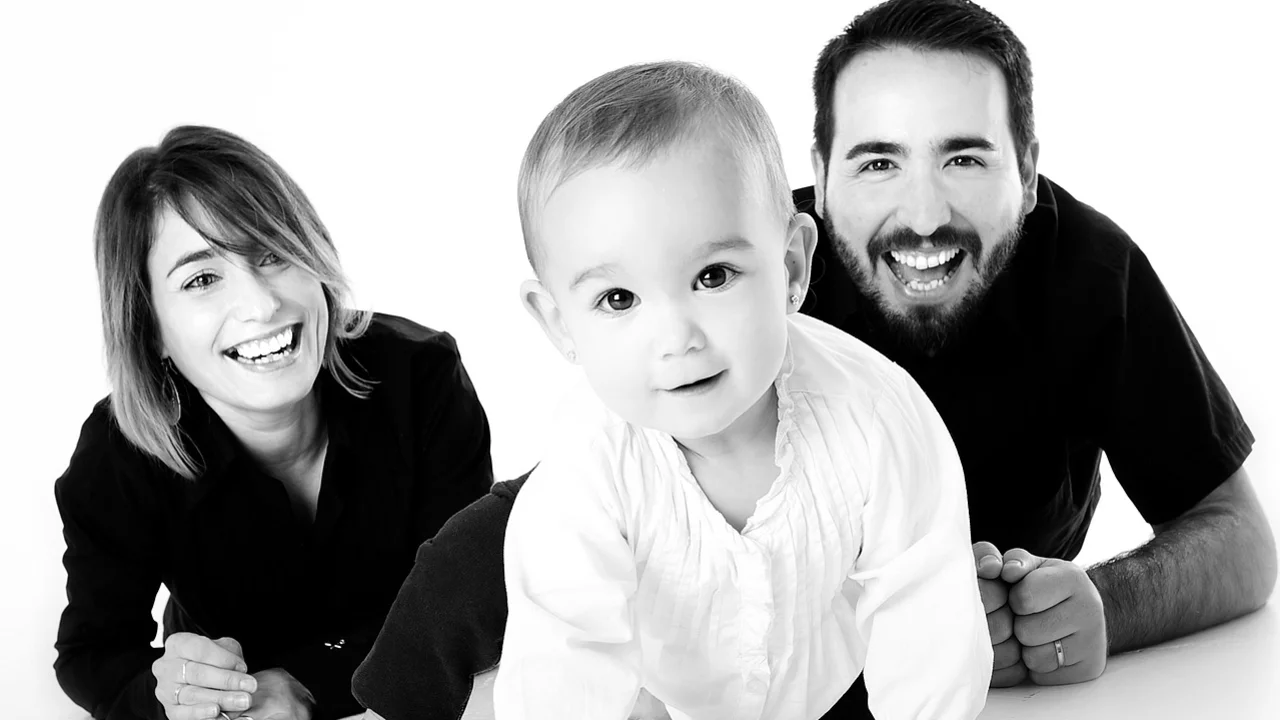 Glückliche Eltern mit Baby, das krabbelt.