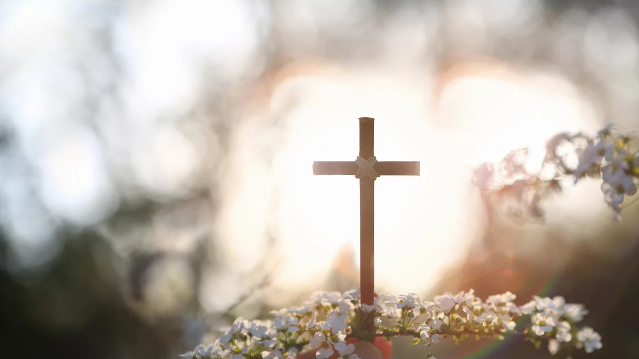 belichtetes Kreuz mit Blüten...