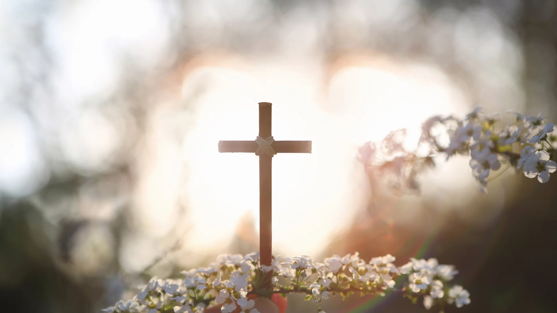 belichtetes Kreuz mit Blüten...