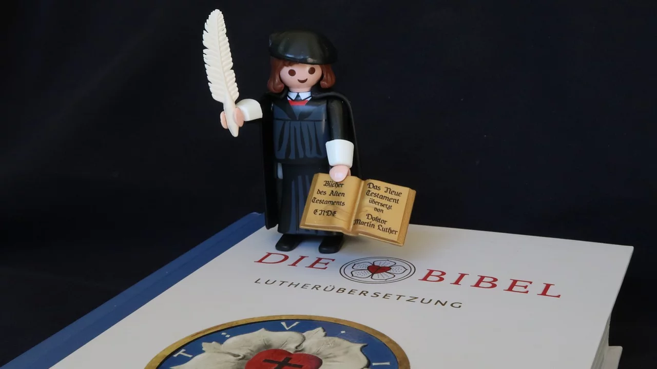 Playmobil-Figur von Martin Luther auf einer Bibel.