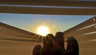 Blick durch eine Jalousie eines Fensters auf die Sonne