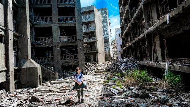 Ein Frau steht in einem verwüsteten Wohngebiet.