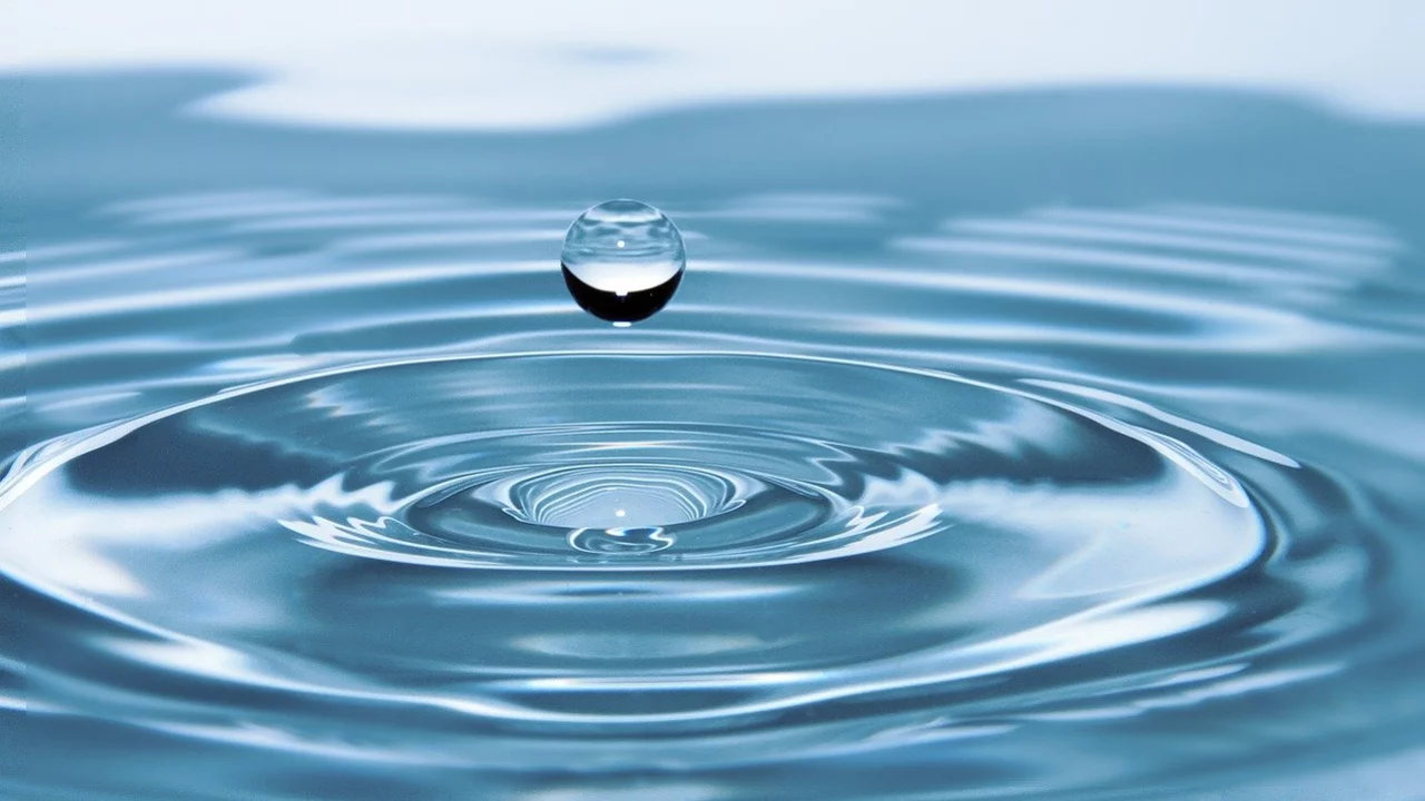 Wassertropfen fällt ins Wasser.