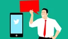 Ein Mann im weißen Hemd und roten Krawatte hält eine Sprechblase in der Hand, die eine Nachricht symbolisiert. Neben ihm befindet sich ein Smartphone mit dem Twitter-Logo auf dem Bildschirm. Der Hintergrund ist einfarbig grün.