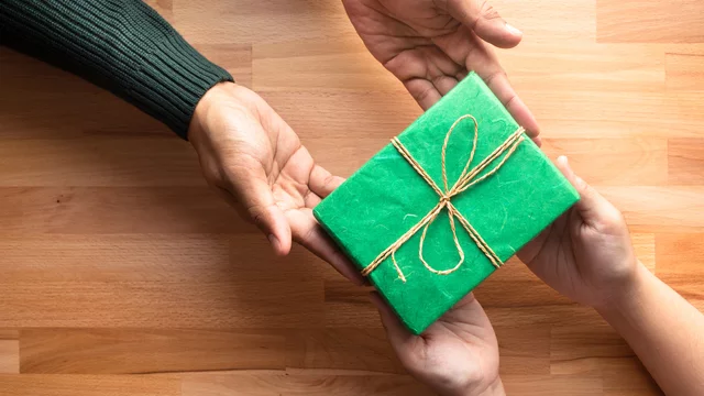 Hände reichen sich ein Geschenk