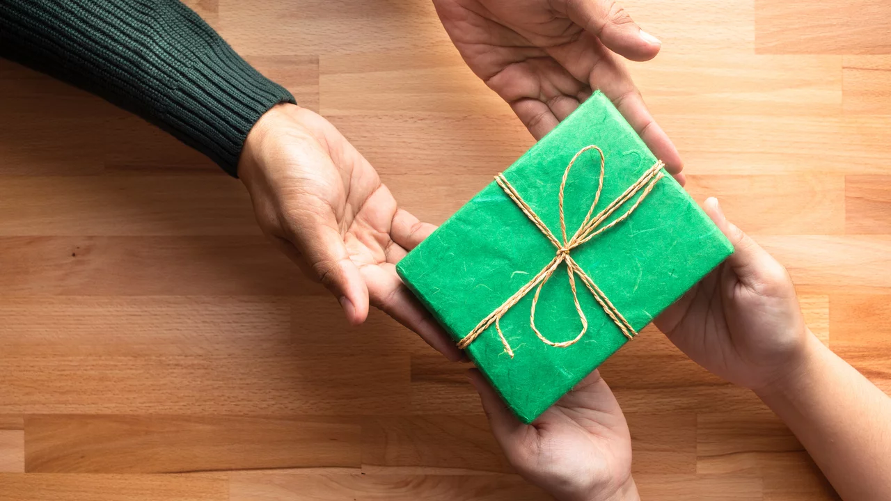 Hände reichen sich ein Geschenk